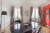 Dining area in restored period apartment with stucco ceiling and red accent wall