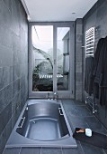 Sunken bathtub in grey modern bathroom