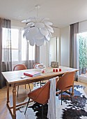 Rustic wooden table and cognac-brown leather chairs on cowhide rug