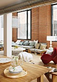 Dining area and lounge area in loft apartment with brick wall