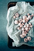 Mini meringues with paper on a baking tray