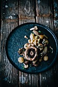 Assorted mushrooms with onions and herbs on a metal plate