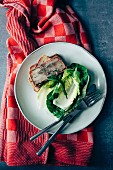 Home-made potato terrine with bacon, fresh herbs and lettuce