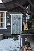 Swedish wooden house with snow and fir branches outside front door