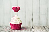 Cupcake decorated with a heart shaped cake pick