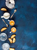 Coffee espresso in cups with italian cantucci, cookies and milk in jug over dark blue background
