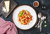 Pasta penne with tomato sauce, basil and roasted tomatoes served with parmesan cheese