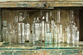 Various glass bottles in rustic kitchen cupboard