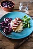 Chicken breast wrapped in bacon on a bed of mashed potatoes with red cabbage & blackberry coleslaw and watercress