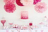 Kuchen und Gebäck in rosa Tönen auf einem Buffettisch
