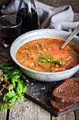 Rustic minestrone soup with tomatoes, green beans and basil