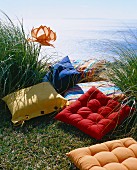 Colourful cushions on grass next to the sea
