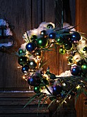 Christmas wreath with peacock figurine, feathers and fairy lights