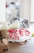 Rosa Babyschuhe neben anderen Schuhen