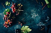 Red grapes with leaves on a dark surface