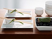 A Japanese table setting with a tea whisk and bowls