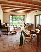 Dining area and couch on terracotta-tiled floor in Mediterranean interior