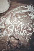'I Love Xmas' written in flour on a wooden board
