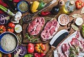 Zutaten für Fleischgericht: Lammfleisch, Reis, Olivenöl, Gewürze und Gemüse auf Holzuntergrund