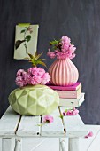 Pink cherry blossom in pastel vases with structured surfaces