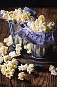 Gesalzenes Popcorn serviert in kleinen Eimern mit lila Papier