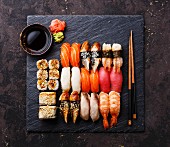 Verschiedene Nigir- und Maki-Sushi: auf schwarzer Schieferplatte