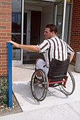 Man in Wheelchair Operating Door