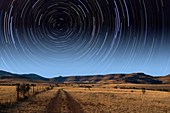 Star trails over lonely road