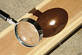 Magnifying glass focusing sun light