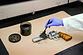 Forensic Technician Examining Pistol