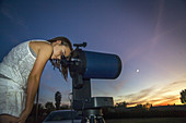 Girl using Telescope in Backyard