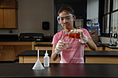 Student Pours Liquid Contents into Beaker