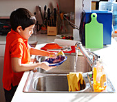 Young Boy Washing Dishes