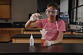 Student Pours Liquid Contents into Beaker