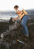 Volcanologist measuring speed of lava flow