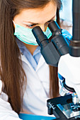 Lab technician using microscope