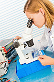 Technician using microscope