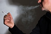 Man smoking a cigarette exhaling smoke