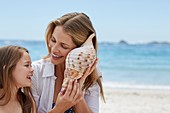 Mother and daughter with seashell