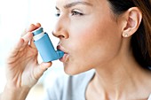 Young woman using inhaler