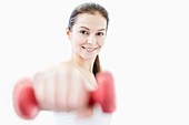 Smiling young woman holding dumbbell