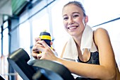 Woman holding water bottle in gym