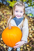 Girl holding pumpkin