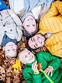 Family lying on dried leaves