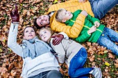 Family lying on dried leaves