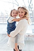 Pregnant mother lifting Girl