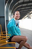 Woman sitting on railway platform smiling