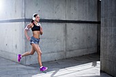 Woman wearing headphones running