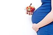 Pregnant woman holding fruit salad