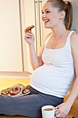 Pregnant woman eating biscuit